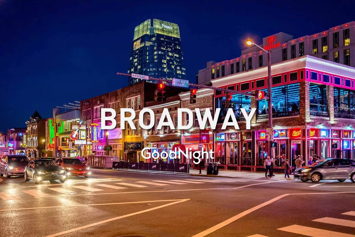 A lively Nashville street scene at night featuring neon lights, bustling sidewalks filled with people, cars driving by, and tall buildings illuminated against the city sky. The vibrant atmosphere captures the essence of Nashville's nightlife and entertainment district.
